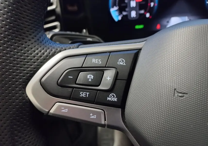 Gros plan sur les commandes de régulateur de vitesse au volant perforé du Volkswagen Tiguan 1.5 eTSI 150ch DSG7 Black R-Line.