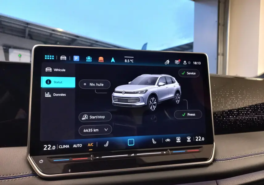 Écran tactile intérieur affichant un Volkswagen Tiguan blanc en vue 3/4 avant avec statut véhicule et options.