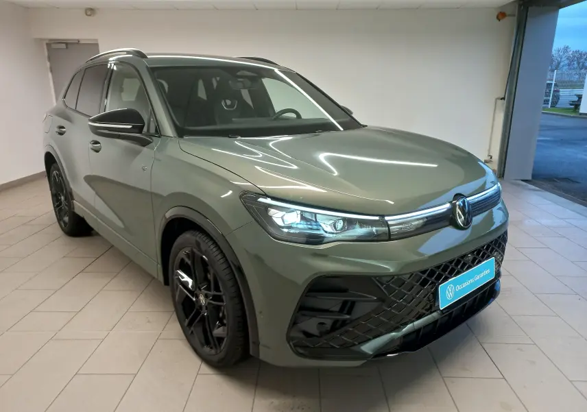 Volkswagen Tiguan 1.5 eTSI 150ch en Vert Cipressino, vue 3/4 avant avec jantes noires et calandre R-Line noire.