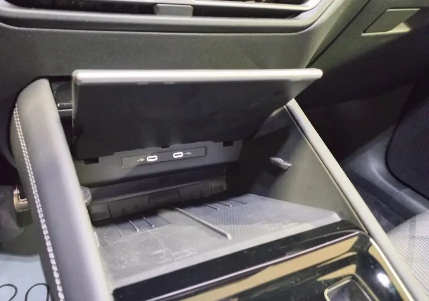 Gros plan intérieur sur la console centrale du Volkswagen Tiguan 2025, montrant le compartiment ouvert avec ports USB-C.