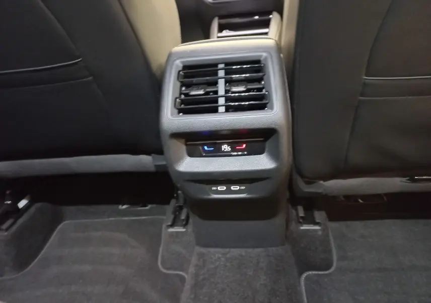 Vue rapprochée de la console arrière noire avec commandes de climatisation et ports USB du Volkswagen Tiguan 2025.