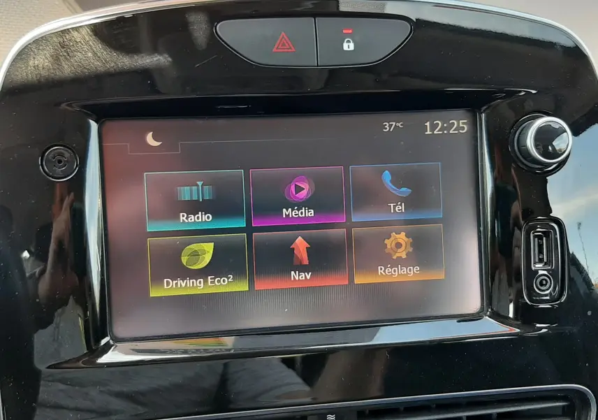 Écran tactile central de la Renault Clio IV gris titanium, affichant les options radio, média, téléphone, navigation et réglages.
