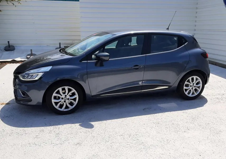 Renault Clio IV gris titanium vue de profil côté gauche, avec jantes alliage et lignes épurées.