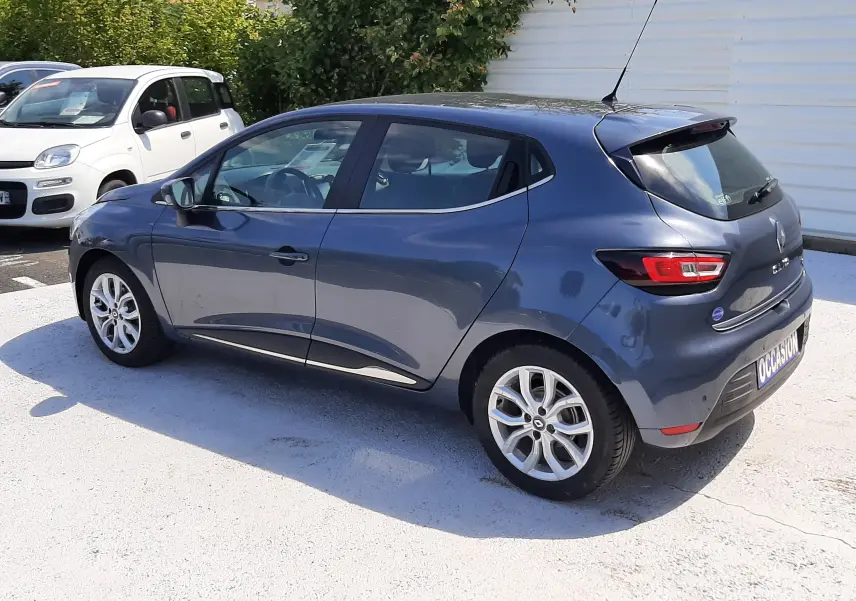 Renault Clio IV gris titanium vue 3/4 arrière droit, compacte cinq portes avec jantes alliage et feux LED.