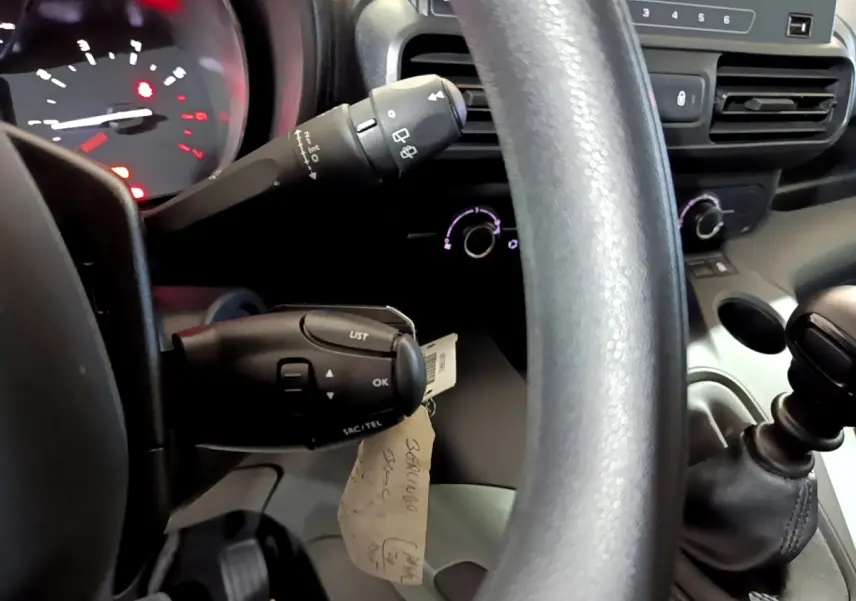Vue rapprochée du volant et du levier de vitesses manuel dans l’habitacle noir du Citroën Berlingo blanc 2019.