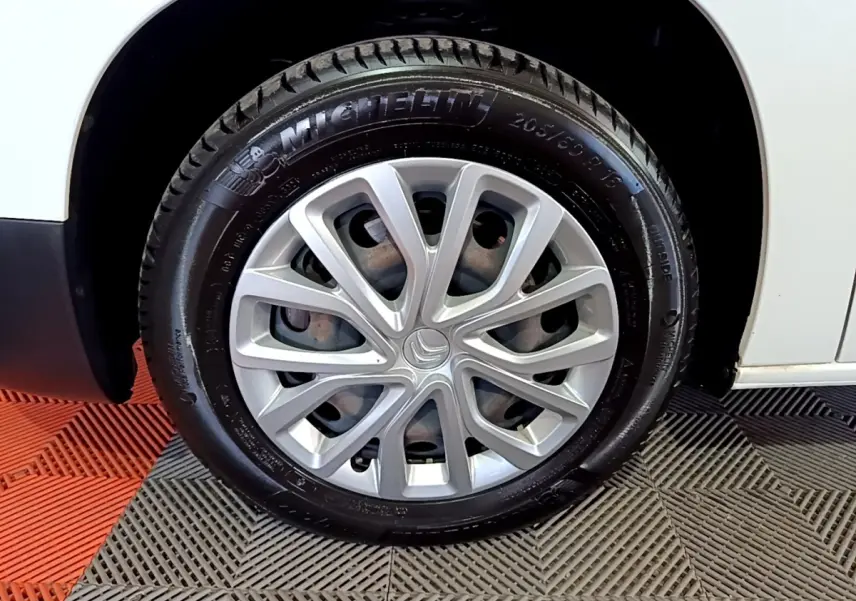 Gros plan sur la roue avant droite blanche d'un Citroën Berlingo XL 2019 avec jante argentée et pneu Michelin.