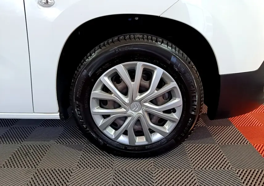 Gros plan sur la roue avant gauche blanche d’un Citroën Berlingo XL 2019 avec jante argentée et logo Citroën central.