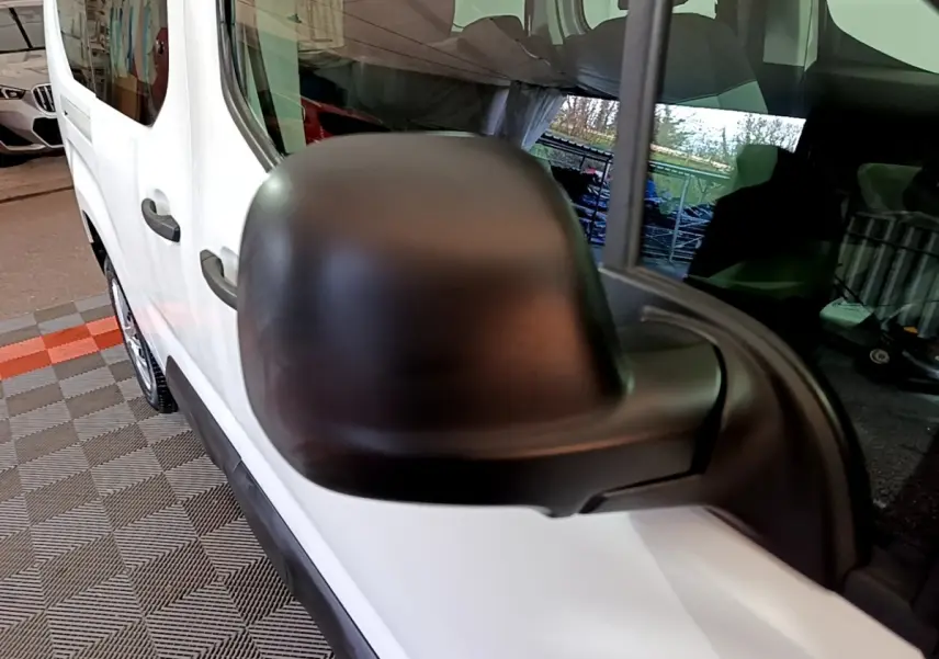 Gros plan sur le rétroviseur noir côté conducteur du Citroën Berlingo XL blanc, vue latérale gauche.
