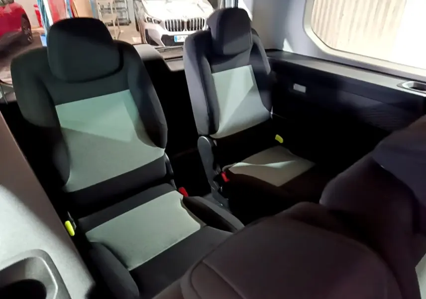 Vue intérieure sur les sièges arrière gris et noirs du Citroën Berlingo XL blanc, avec banquette fractionnée 3 places.
