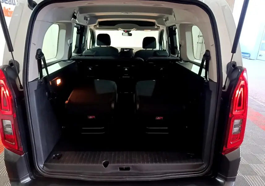 Vue arrière ouverte du Citroën Berlingo blanc XL montrant l’intérieur spacieux et les sièges arrière rabattus.