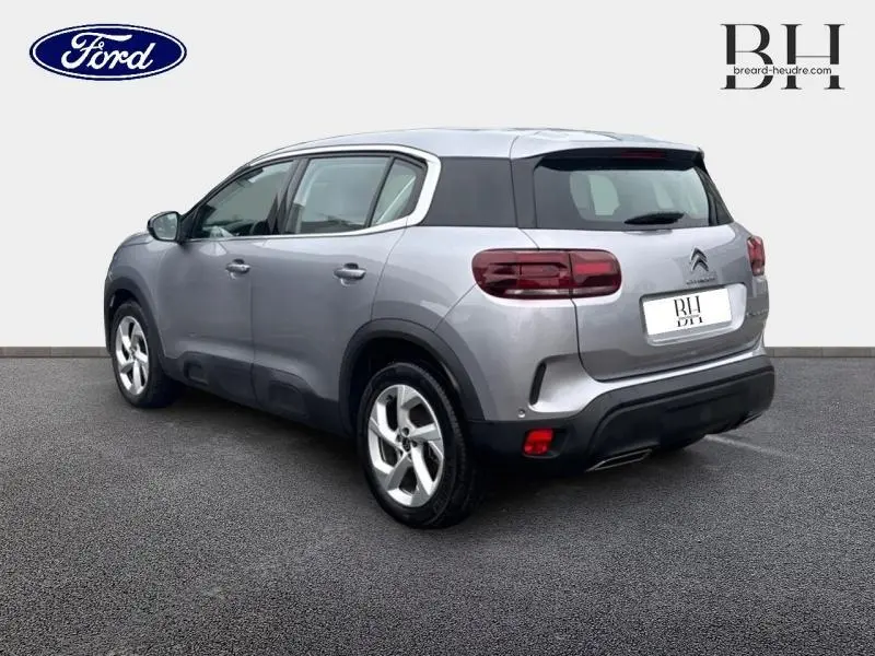 Vue 3/4 arrière droite d'un Citroën C5 Aircross 2023 gris acier avec feux arrière LED et jantes alu cinq branches.