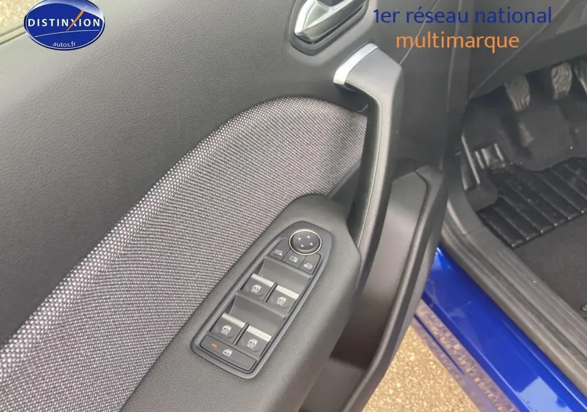 Détail de la porte avant gauche avec commandes électriques sur Renault Captur Bleu Iron 2025, intérieur noir.