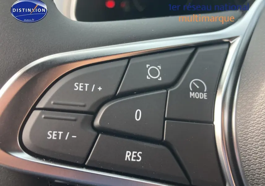 Gros plan sur les commandes de régulateur de vitesse au volant du Renault Captur bleu iron 2025.
