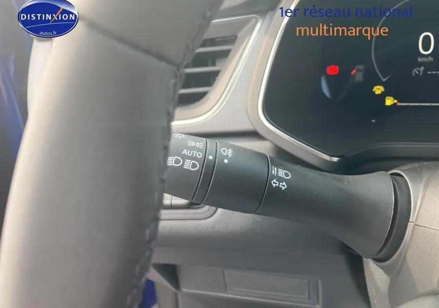 Détail du commodo d'éclairage à gauche du volant dans l'habitacle du Renault Captur Bleu Iron 2025.