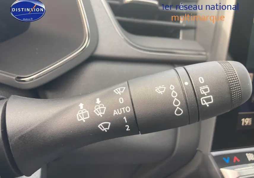 Gros plan sur la commande d’essuie-glace du Renault Captur Bleu Iron, intérieur moderne avec écran tactile partiel visible.