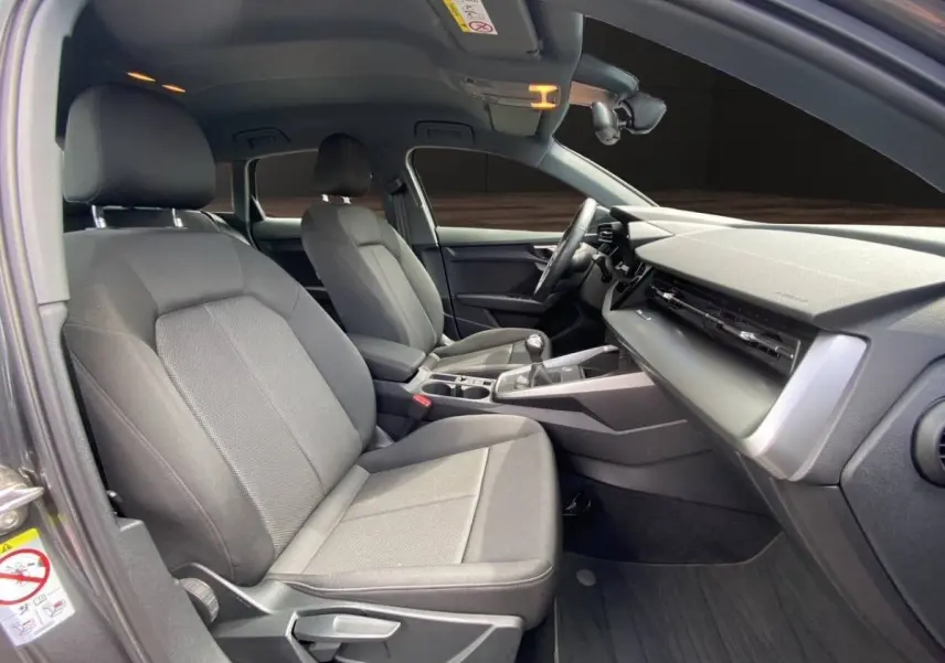 Vue intérieure côté conducteur de l'Audi A3 30 TFSI 110 S Line 2021 avec sièges gris et tableau de bord moderne.