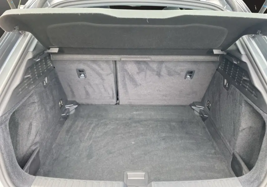 Coffre ouvert de l'Audi A3 30 TFSI S Line gris foncé, montrant un espace de chargement propre et spacieux.