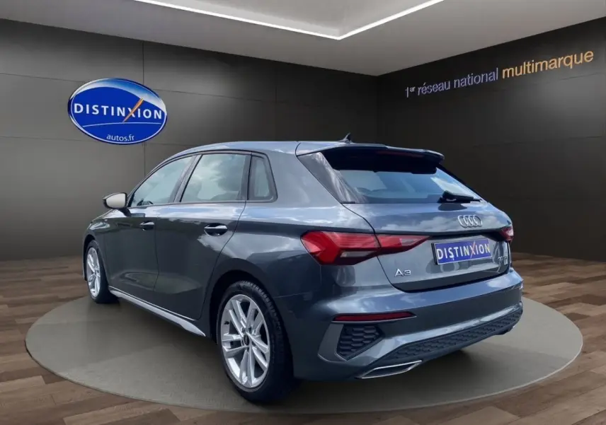 Audi A3 30 TFSI S Line gris foncé vue 3/4 arrière droit, avec jantes alliage et feux LED distinctifs.
