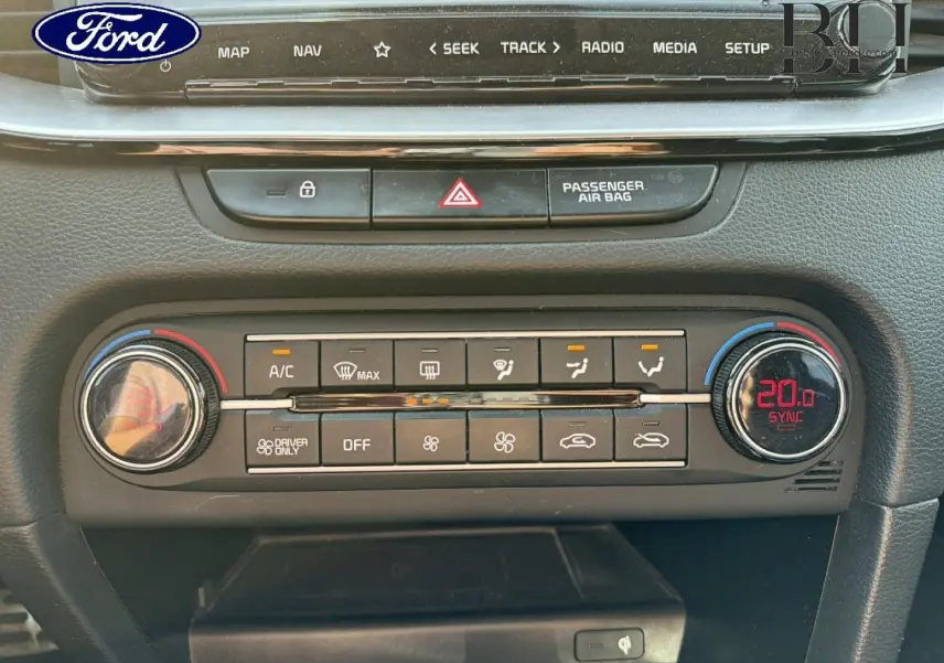 Panneau de commande de climatisation avec affichage digital rouge, boutons noirs et finition mate dans un intérieur Ford.