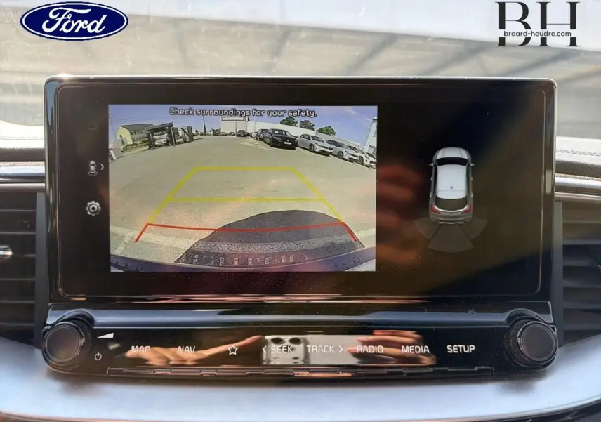 Écran tactile intérieur montrant la caméra de recul et l'affichage 360° d'un véhicule en stationnement.