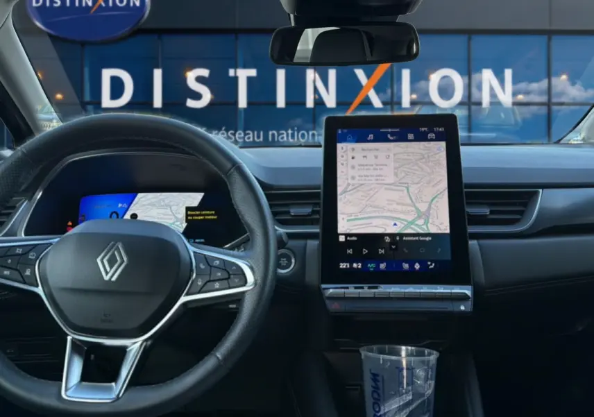 Vue intérieure frontale du tableau de bord gris du Renault Symbioz 2025 avec écran tactile vertical et volant multifonction.