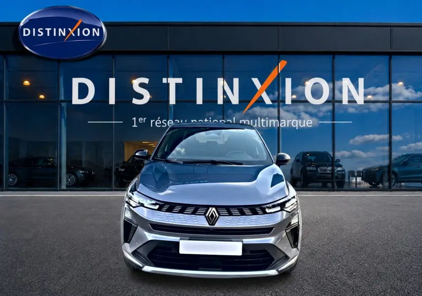 Vue frontale d'une Renault Symbioz gris métallisé 2025 devant une vitrine avec logo Distinxion.