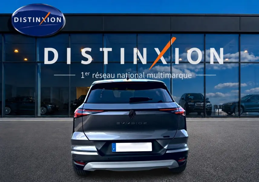 Vue arrière d'un Renault Symbioz gris 2025 stationné devant une vitrine avec logo Distinxion.