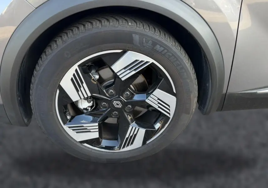 Gros plan sur la roue avant droite du Renault Symbioz gris 2025, avec jante noire et argent au design géométrique.