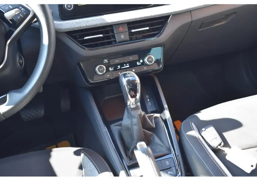 Vue intérieure centrée sur la console centrale et levier de vitesse automatique d'une Skoda Scala blanche glacier, sellerie noire.