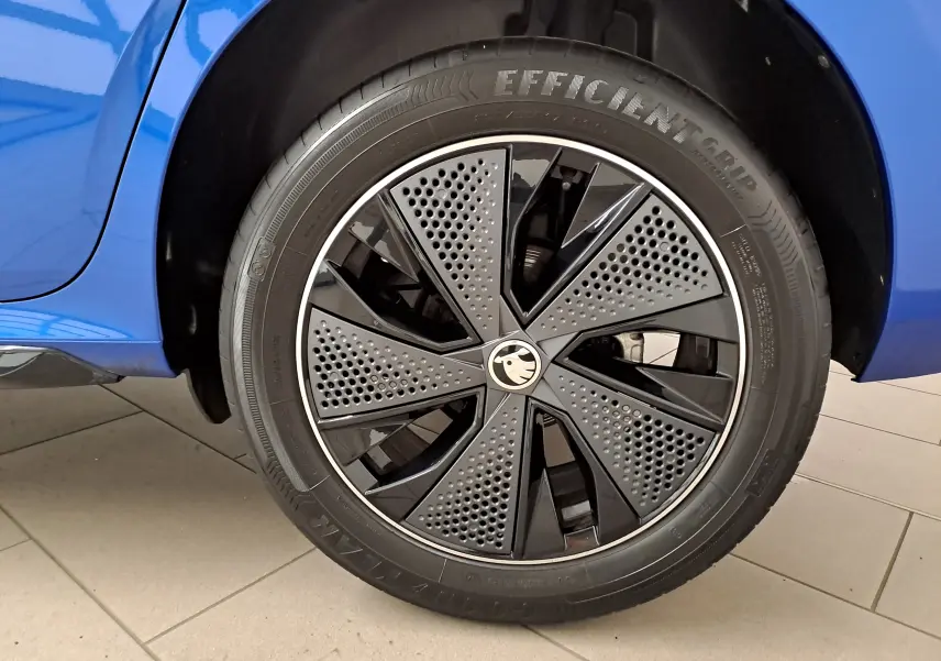 Gros plan sur la roue avant gauche du Skoda Kamiq Bleu RS 2024, mettant en valeur la jante noire au design perforé.