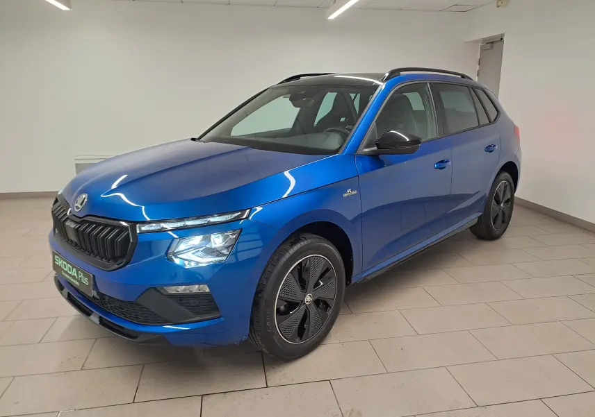 Vue 3/4 avant droite d'un Skoda Kamiq 1.5 TSI 150 DSG7 Monte Carlo bleu RS avec jantes noires et toit noir.