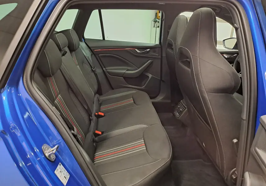Vue intérieure côté gauche des sièges arrière du Skoda Kamiq bleu RS 2024 avec surpiqûres rouges et noires.