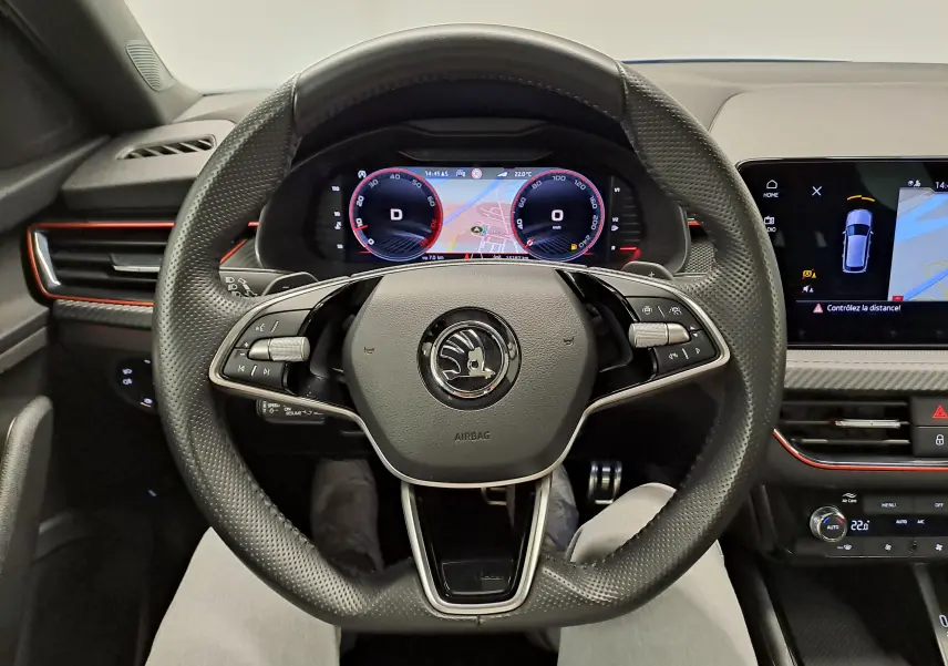 Vue intérieure centrée sur le volant perforé et le tableau de bord numérique du Skoda Kamiq 2024.