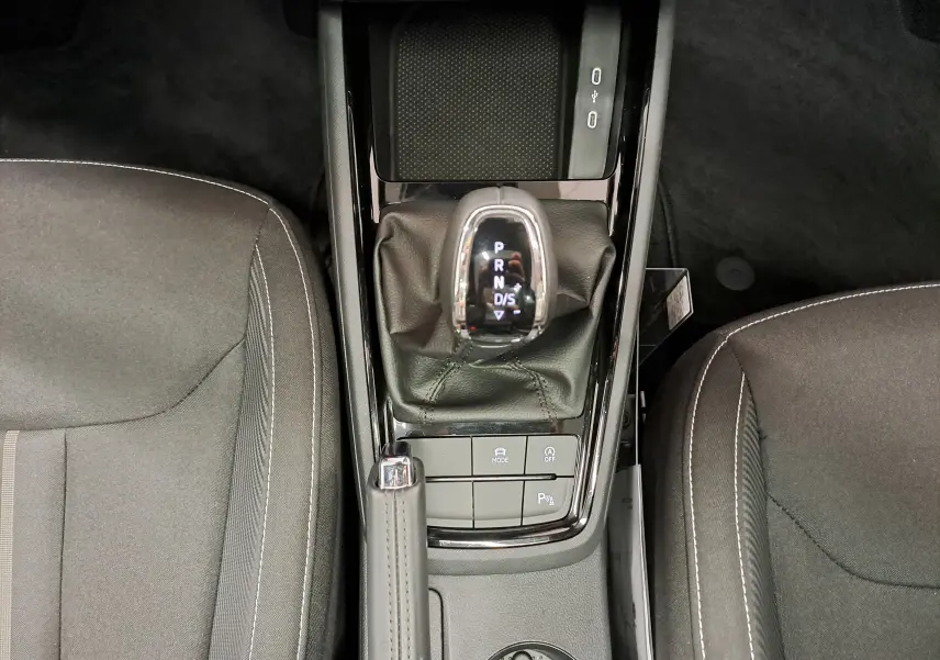 Vue plongeante sur la console centrale du Skoda Kamiq 2024, avec levier de vitesse automatique et sièges gris.