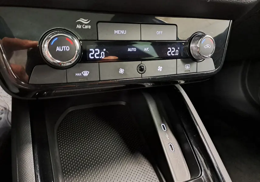 Vue rapprochée de la console centrale du Skoda Kamiq 2024, avec commandes climatisation digitale et ports USB visibles.