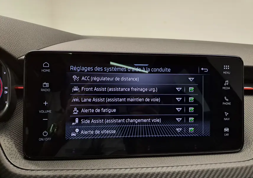 Écran tactile central du Skoda Kamiq 2024 affichant les réglages des aides à la conduite avec interface noire et boutons tactiles.