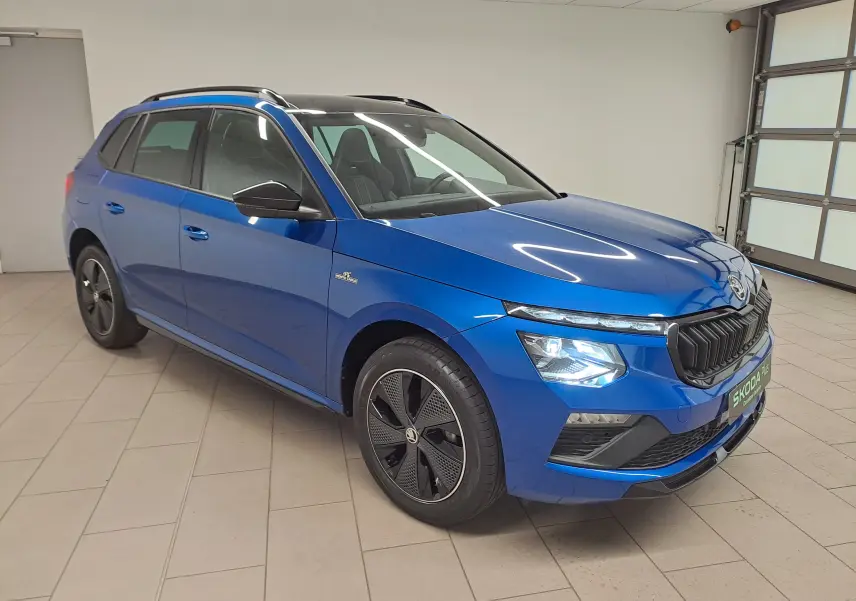 Vue 3/4 avant droite du Skoda Kamiq 2024 bleu RS avec jantes noires et calandre noire distinctive Monte Carlo.