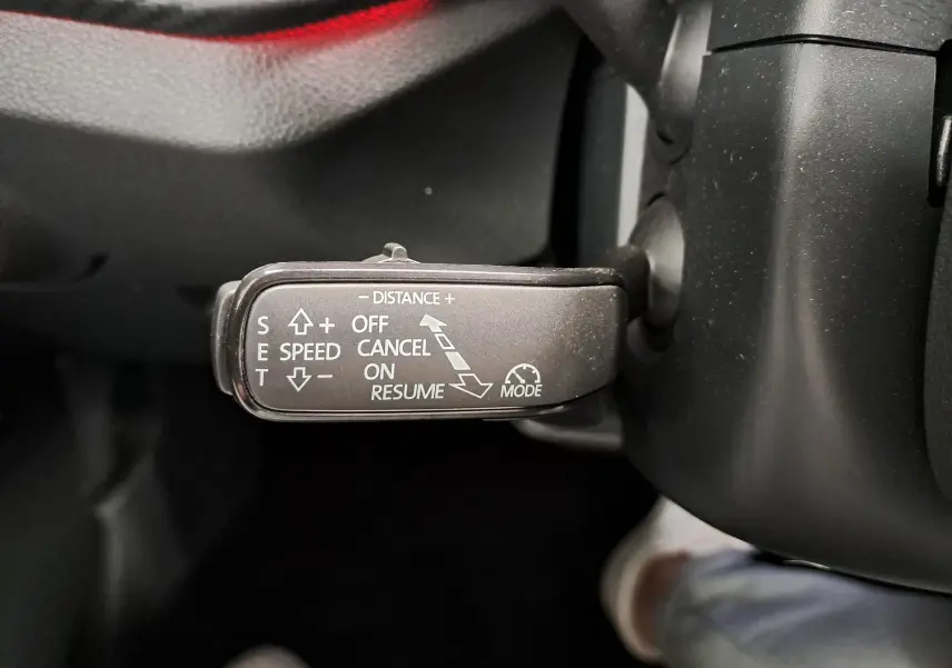Gros plan sur le levier de commande du régulateur de vitesse dans l'habitacle noir du Skoda Kamiq Bleu RS 2024.