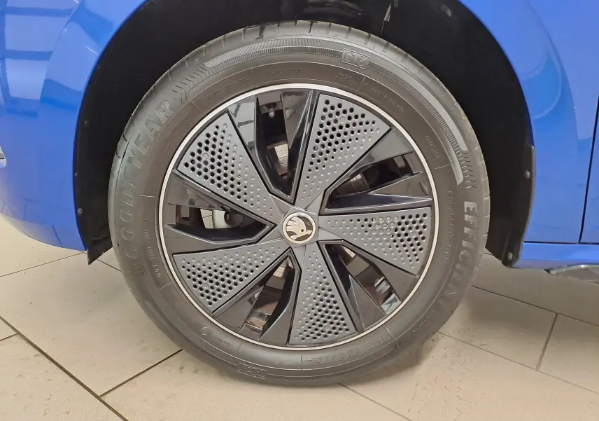 Gros plan sur la roue avant gauche bleu RS du Skoda Kamiq 2024 avec jante noire au design perforé distinctif.