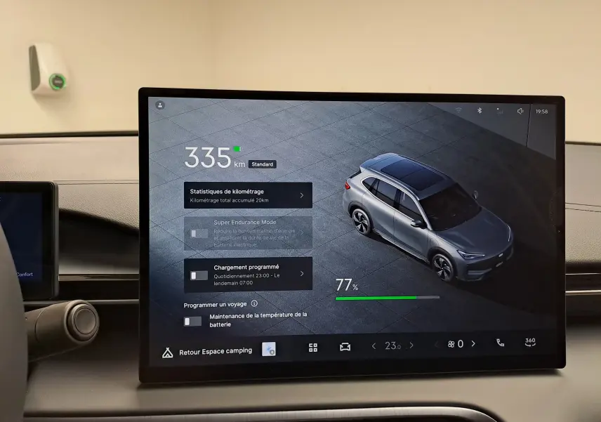 Vue intérieure de l'écran tactile du tableau de bord montrant une image 3/4 arrière du GEELY E5 PRO gris Moonlight avec autonomie et options de charge.
