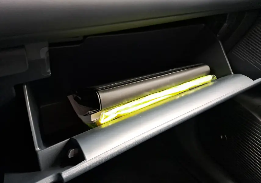 Coffre à gants ouvert du Geely E5 PRO 218ch 60kWh 2026 avec manuel et gilet jaune visible à l'intérieur.