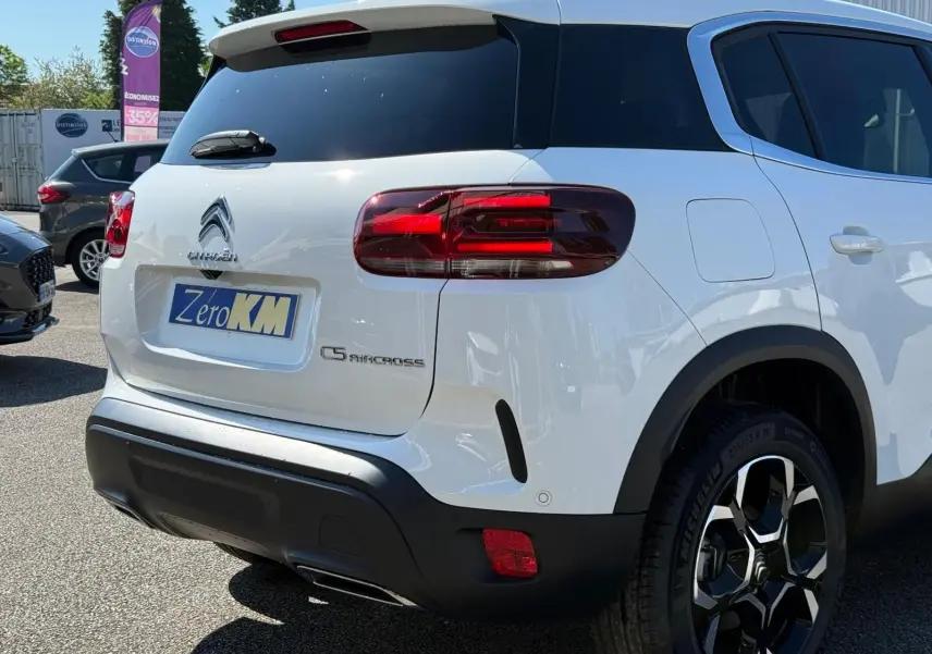 Vue 3/4 arrière droite d'un Citroën C5 Aircross blanc banquise avec feux arrière LED et jantes bi-ton 18 pouces.