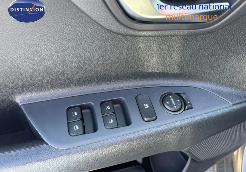 Gros plan sur les commandes de lève-vitres et rétroviseurs côté gauche d'une KIA STONIC gris météore 2024.