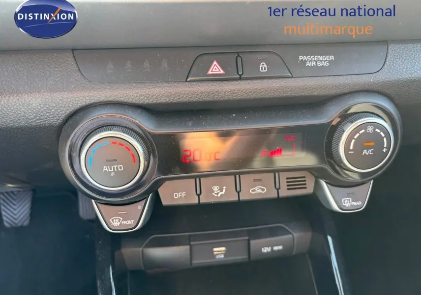 Tableau de bord du Kia Stonic 2024 montrant la console de climatisation automatique avec affichage digital rouge.