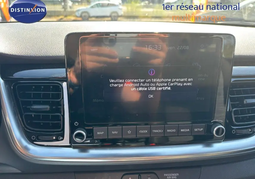 Vue rapprochée de l'écran tactile central du tableau de bord du Kia Stonic gris météore, avec commandes multimédia visibles.