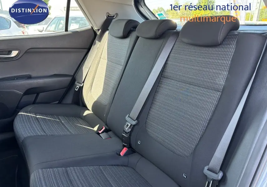 Banquette arrière en tissu gris avec ceintures de sécurité, vue côté gauche de la Kia Stonic 2024 gris météore.