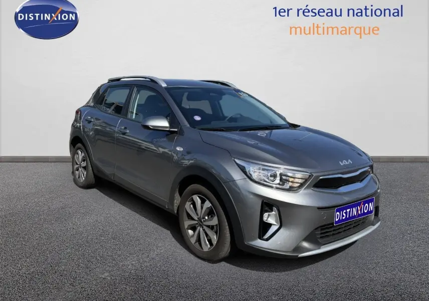 KIA Stonic gris météore en 3/4 avant droit, mettant en valeur ses optiques LED et ses jantes bi-ton.