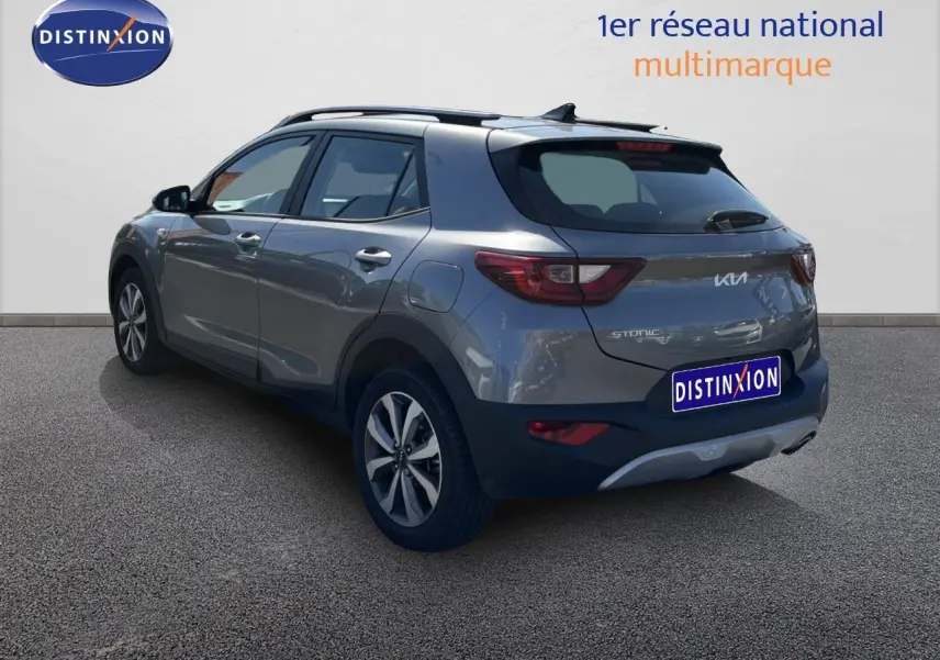 KIA STONIC gris météore vu en 3/4 arrière droit, avec jantes bi-ton et toit noir contrastant.