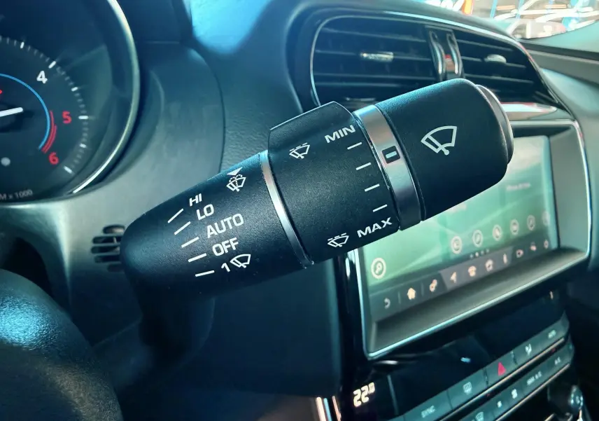 Gros plan sur la commande d'essuie-glace noire dans l'habitacle d'une Jaguar XE 2.0D 180CH Prestige de 2019.