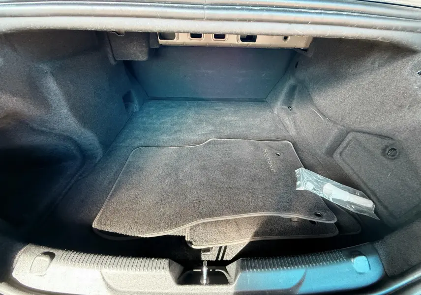 Intérieur du coffre de la Jaguar XE 2019, vue plongeante montrant tapis de sol noirs avec logo Jaguar.
